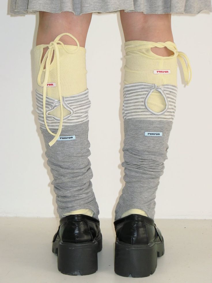 Person wearing layered leg warmers and black platform shoes indoors