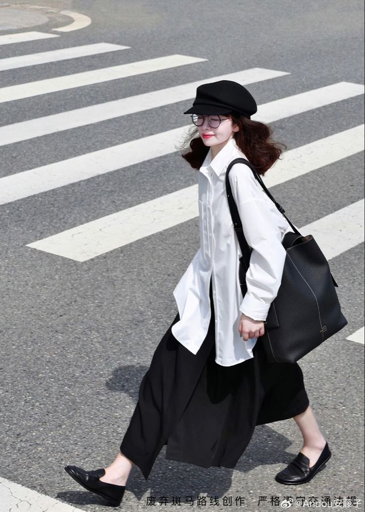 Woman in a black hat and white shirt walking on a crosswalk