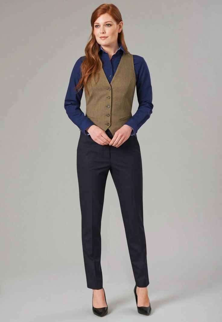 Woman with red hair wearing a brown vest, blue shirt, and dark pants