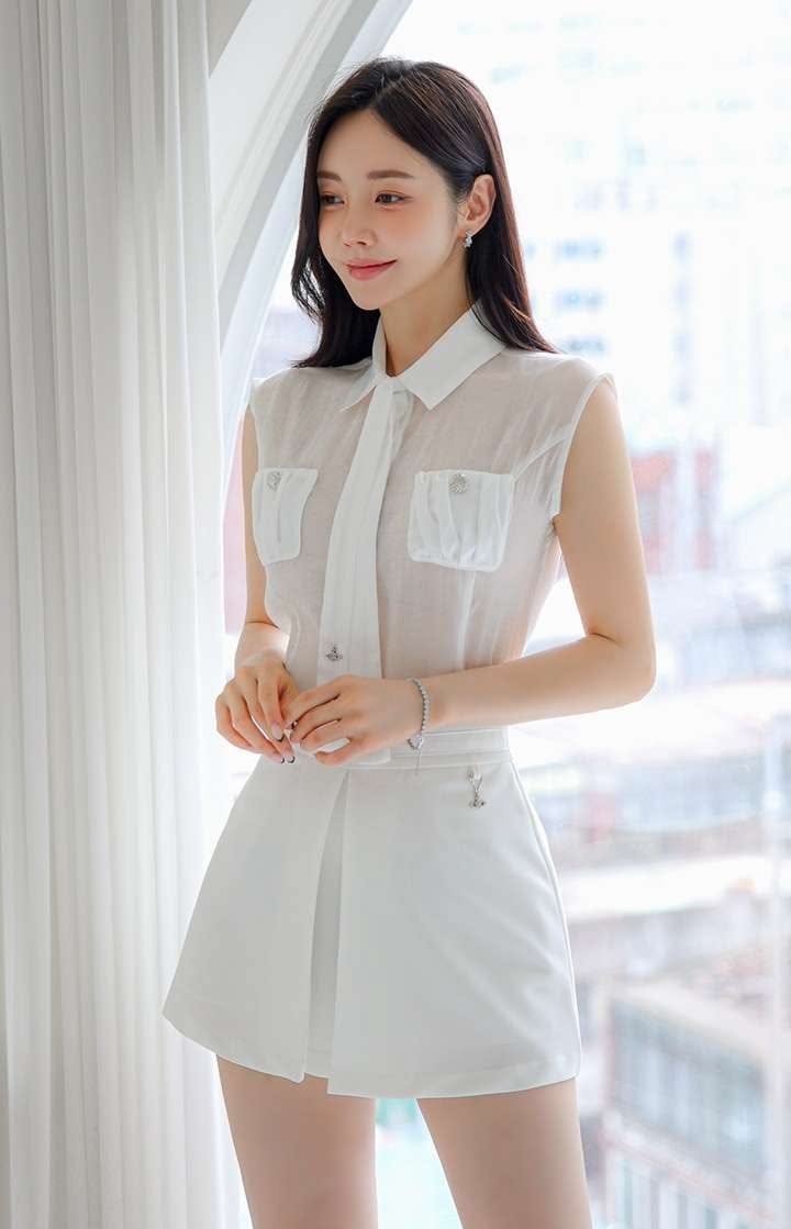 Woman in a white sleeveless shirt and short skirt indoors