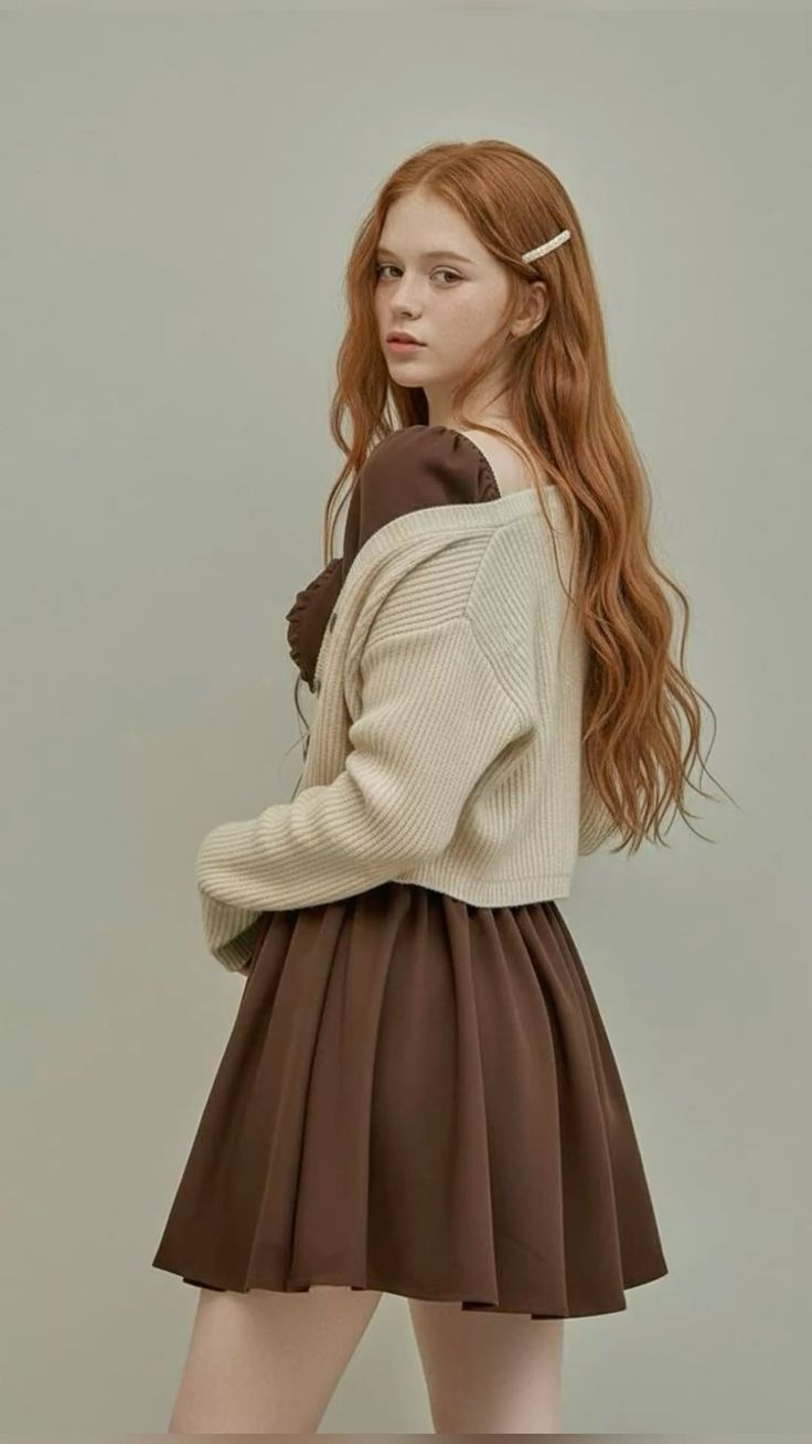 Young woman with long red hair and freckles wearing a brown dress and cardigan