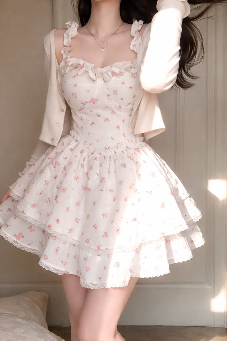 Woman in a white floral dress with a cardigan and ruffle straps