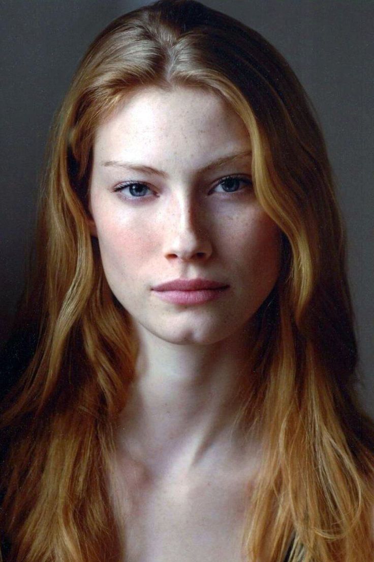 Woman with long red hair and blue eyes in a soft lighting portrait