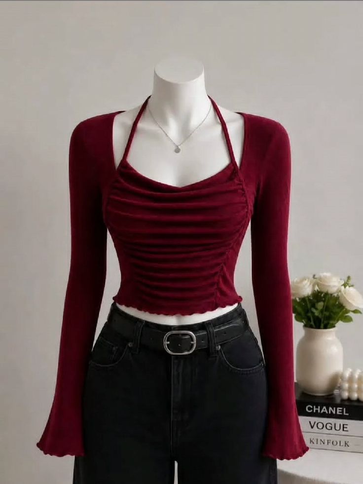 Mannequin wearing a red long-sleeve top and black jeans with a silver necklace