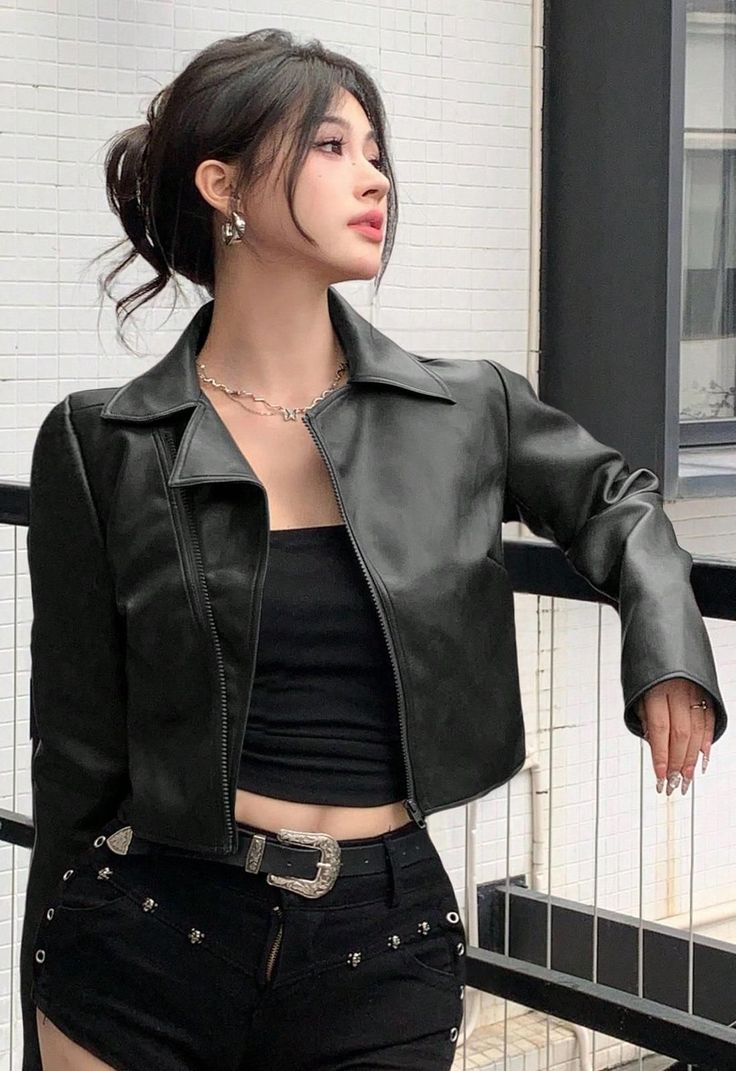 Woman in a black leather jacket and shorts with exposed midriff