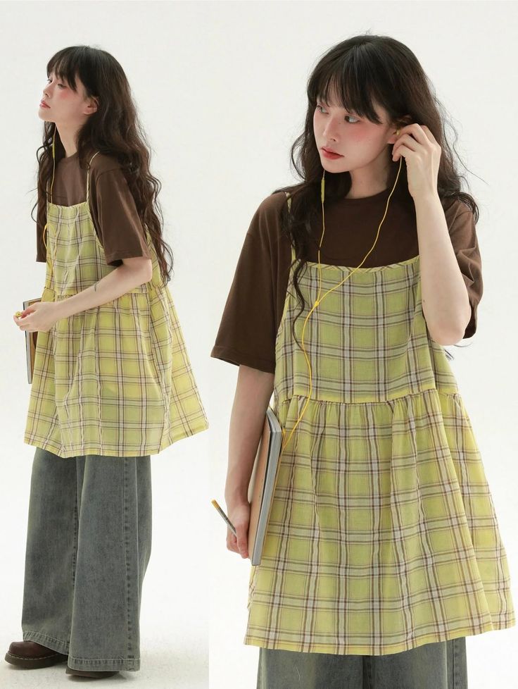 Woman in a plaid dress and wide leg jeans with earbuds on a white background
