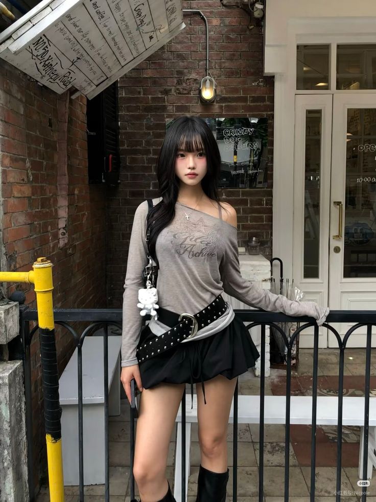 Woman with long black hair wearing an off-shoulder top and mini skirt outdoors