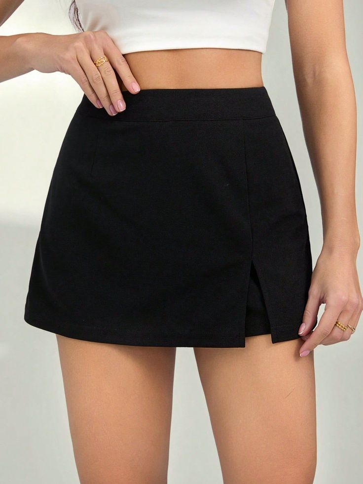 Woman in a black mini skirt and white crop top with exposed midriff