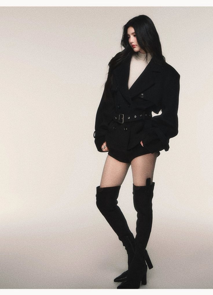 Woman with long black hair wearing a black jacket and thigh-high boots