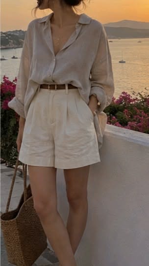 Person in a linen shirt and shorts with a straw bag at sunset