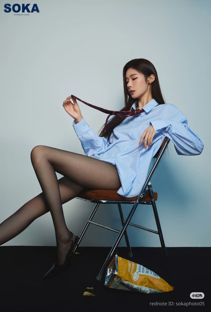 Woman in a striped shirt and black pantyhose sitting on a chair