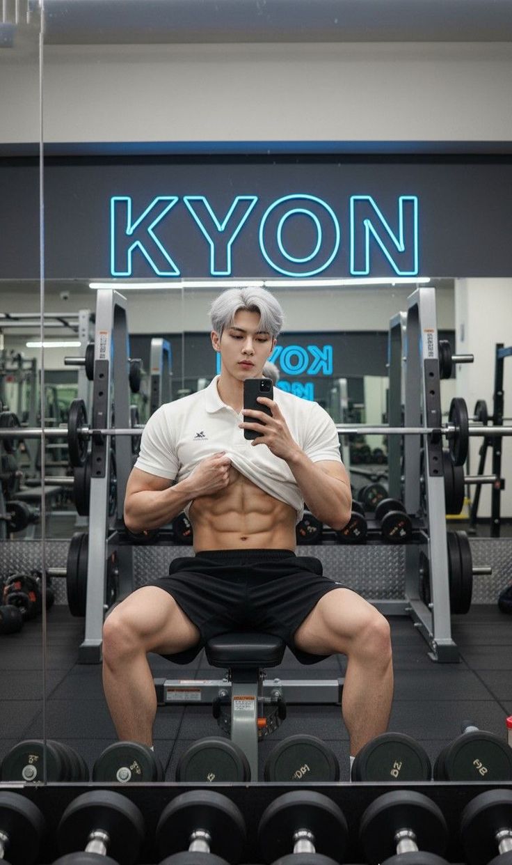 Muscular man with white hair taking a selfie in a gym, showing his abs
