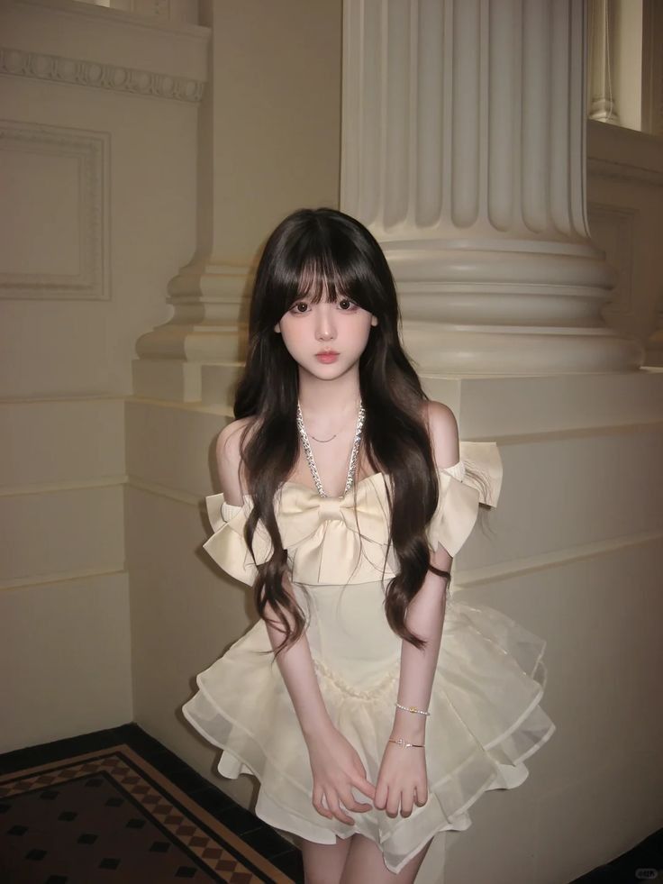 Woman with long dark hair wearing an off-shoulder dress with a large bow