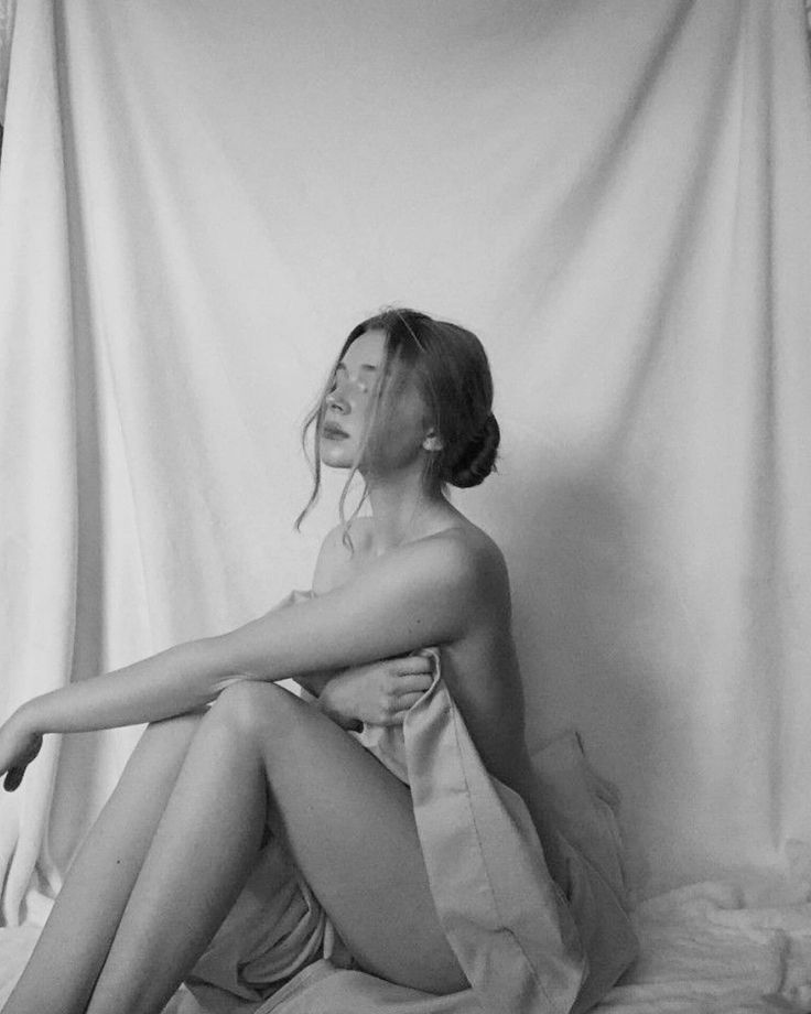Woman with draped fabric in a black and white indoor setting