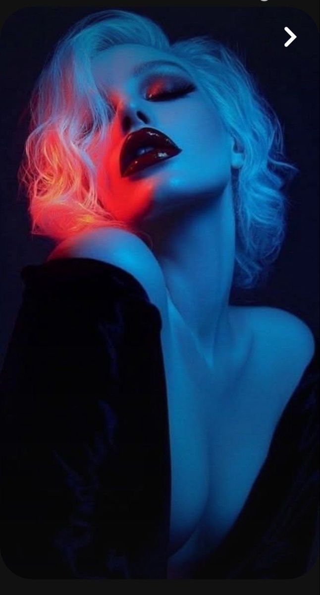Woman with blonde hair and red lipstick in dramatic neon lighting