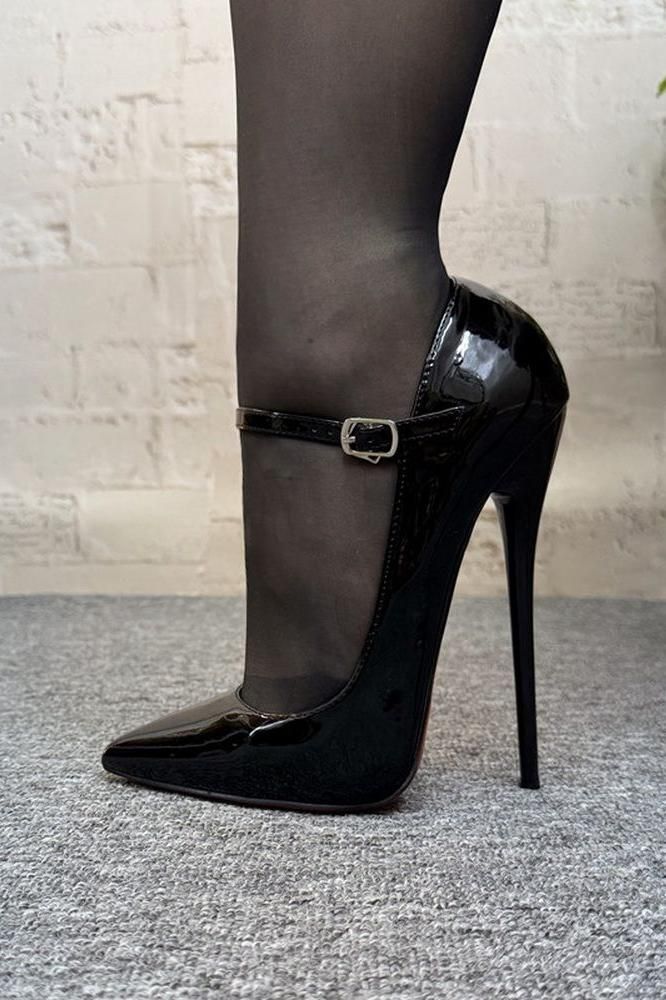 Leg in black stockings and patent leather high heels with an ankle strap
