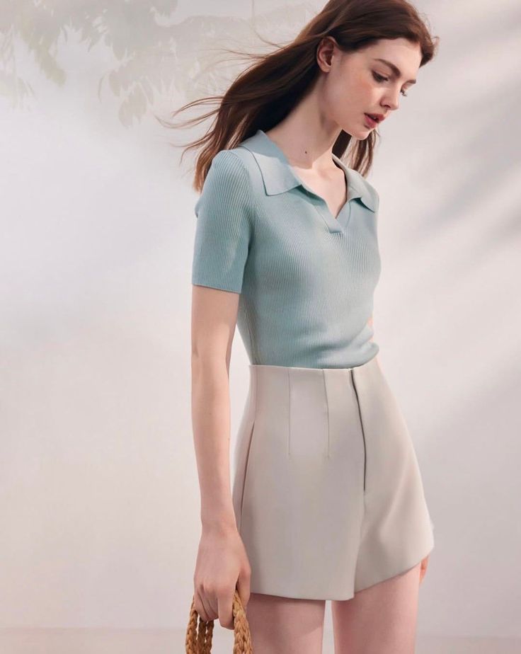 Woman with long hair wearing a polo shirt and high-waisted shorts