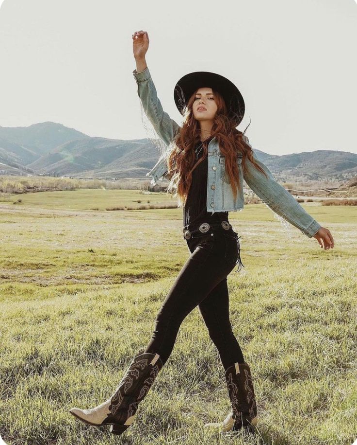 Woman in a cowboy hat and denim jacket walking in a green field