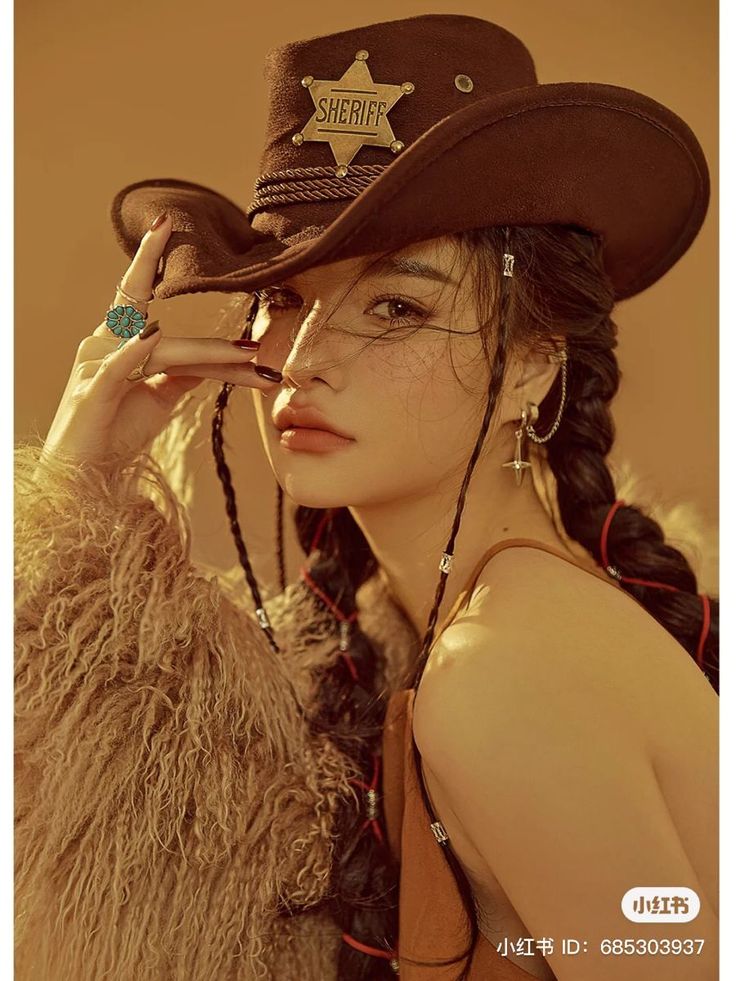Woman in a cowboy hat and fur coat with braided hair and a turquoise ring