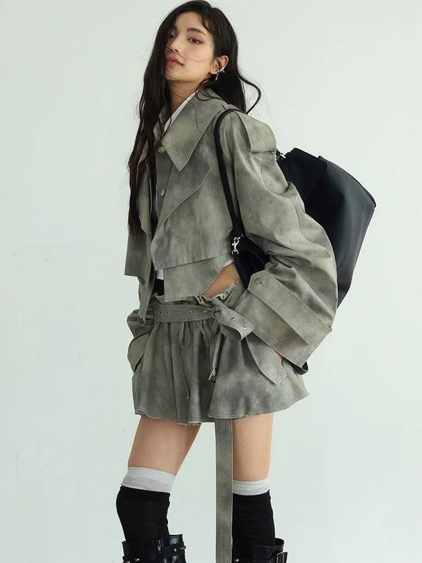 Woman with long hair wearing a cropped jacket and shorts with a black bag