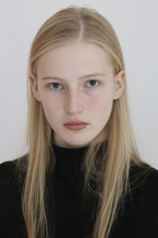 Young woman with long blonde hair and blue eyes wearing a black turtleneck