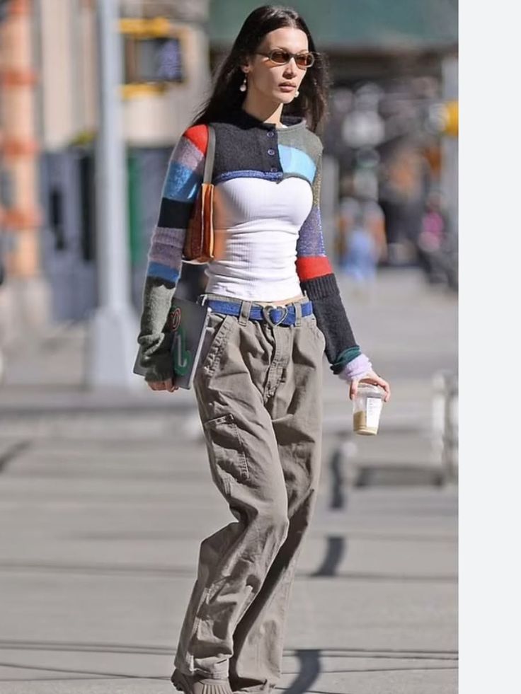Woman in a colorful cropped cardigan and cargo pants walking on a street