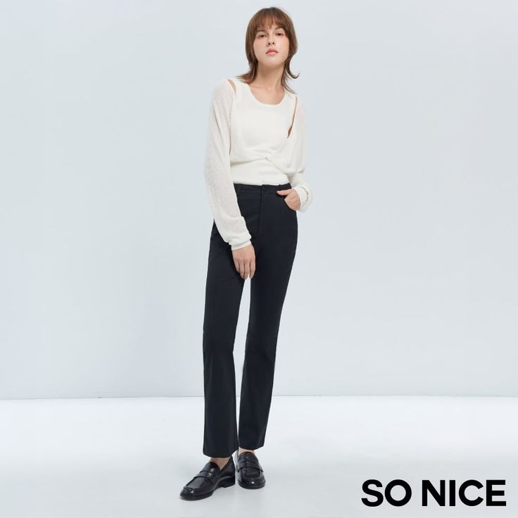 Woman in a white top and black pants posing in a studio