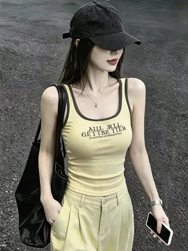 Woman in a baseball cap and tank top holding a phone and bag outdoors