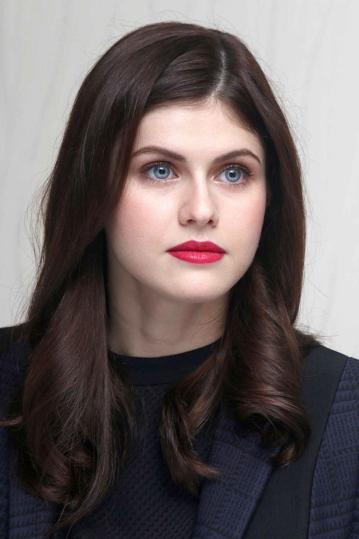 Woman with long dark hair and blue eyes wearing red lipstick