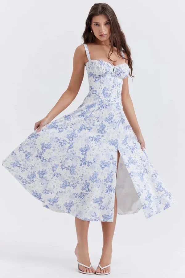 Woman in a white and blue floral dress with a slit, posing on a white background