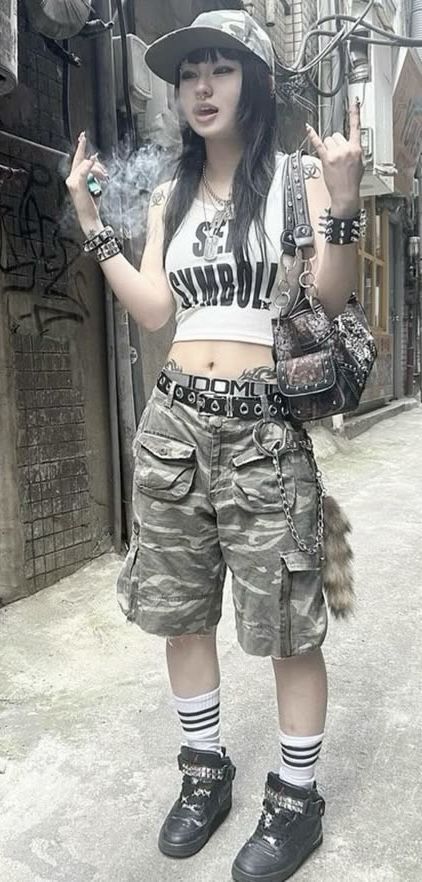 Person in camouflage shorts and a crop top with a cigarette on a street