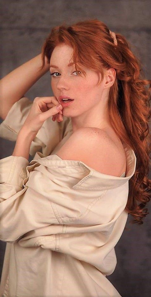 Woman with red hair and freckles wearing an off-shoulder shirt