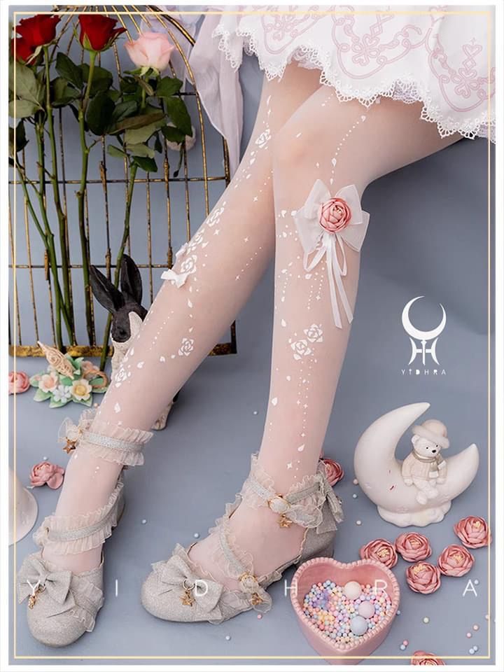 Close up of legs in white floral tights and ruffled mary jane shoes