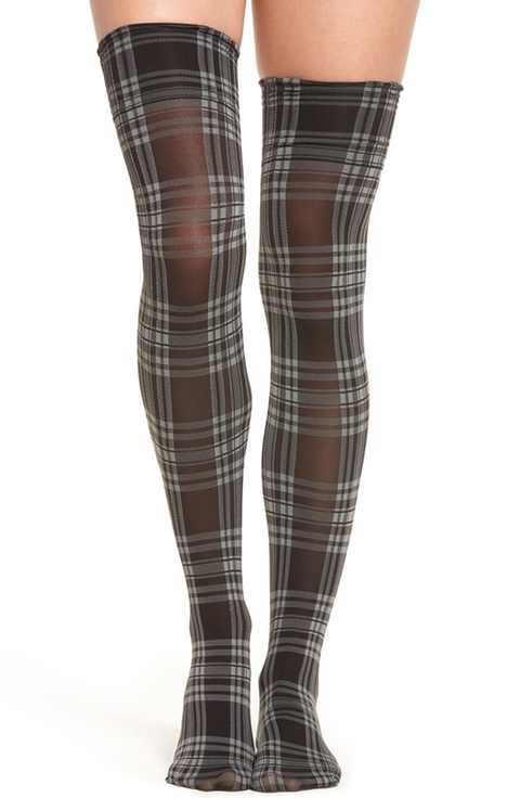 Legs wearing sheer plaid thigh-high stockings against a white background