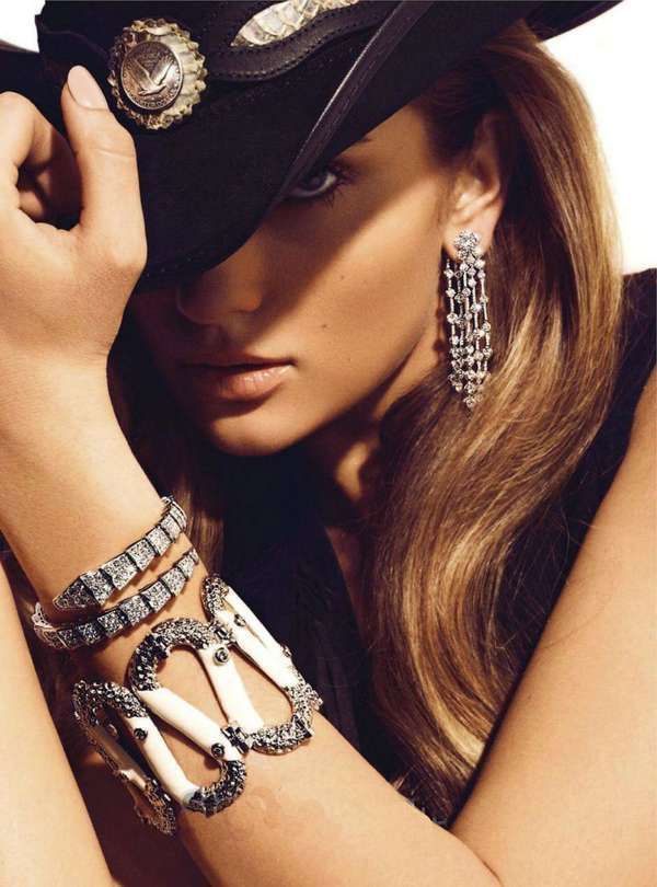 Woman in a cowboy hat with long hair and elaborate jewelry
