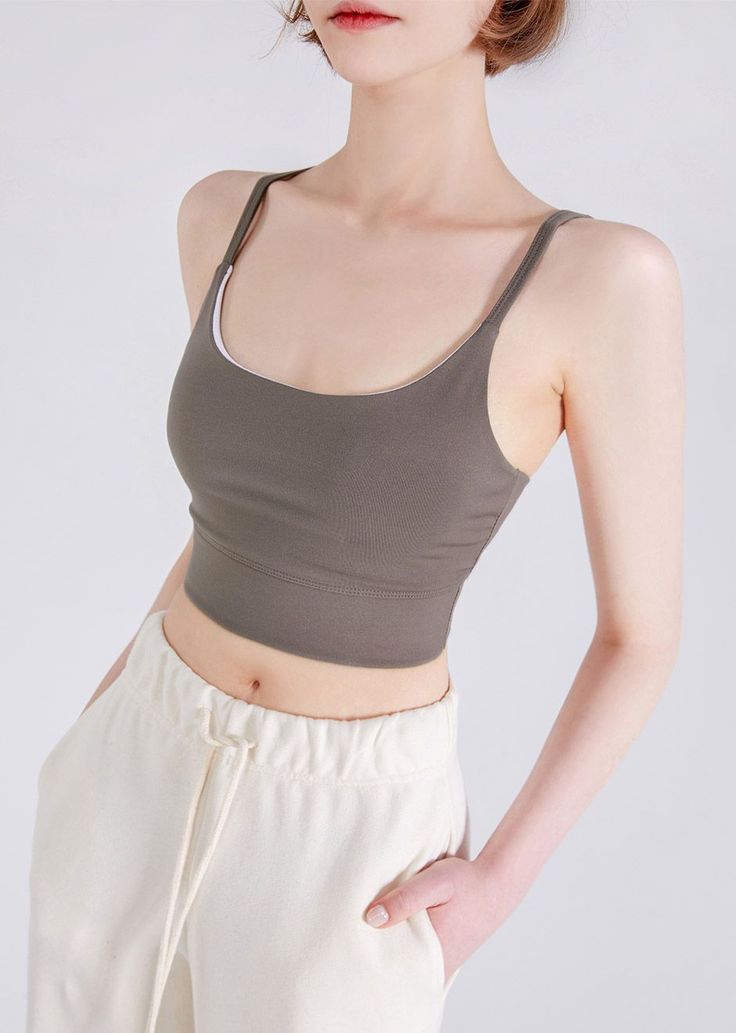 Woman in a crop top and sweatpants with hands in pockets