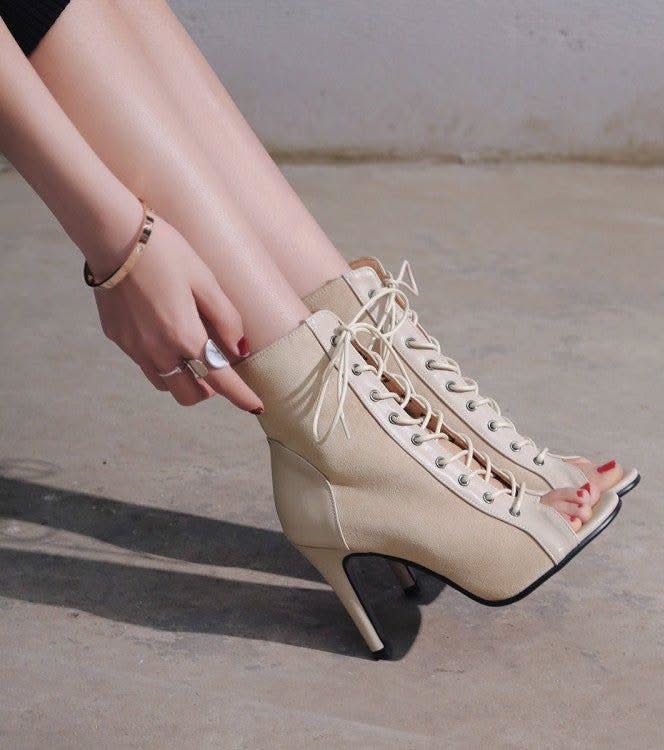 Person wearing beige lace-up peep-toe high heel ankle boots