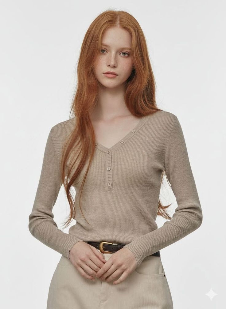 Woman with red hair and freckles wearing a ribbed v-neck top and brown belt