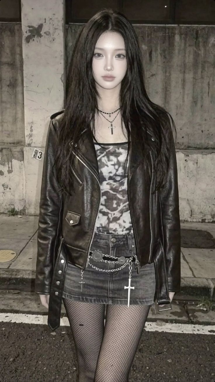 Person with long dark hair wearing a leather jacket and mini skirt outdoors