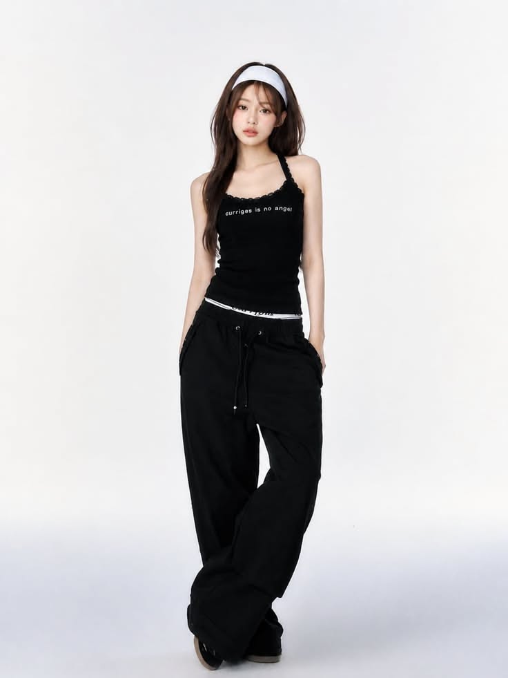 Woman in a black tank top and baggy pants with a white headband