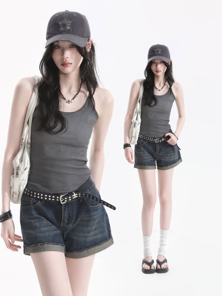 Woman in a tank top, denim shorts, and baseball cap on a white background