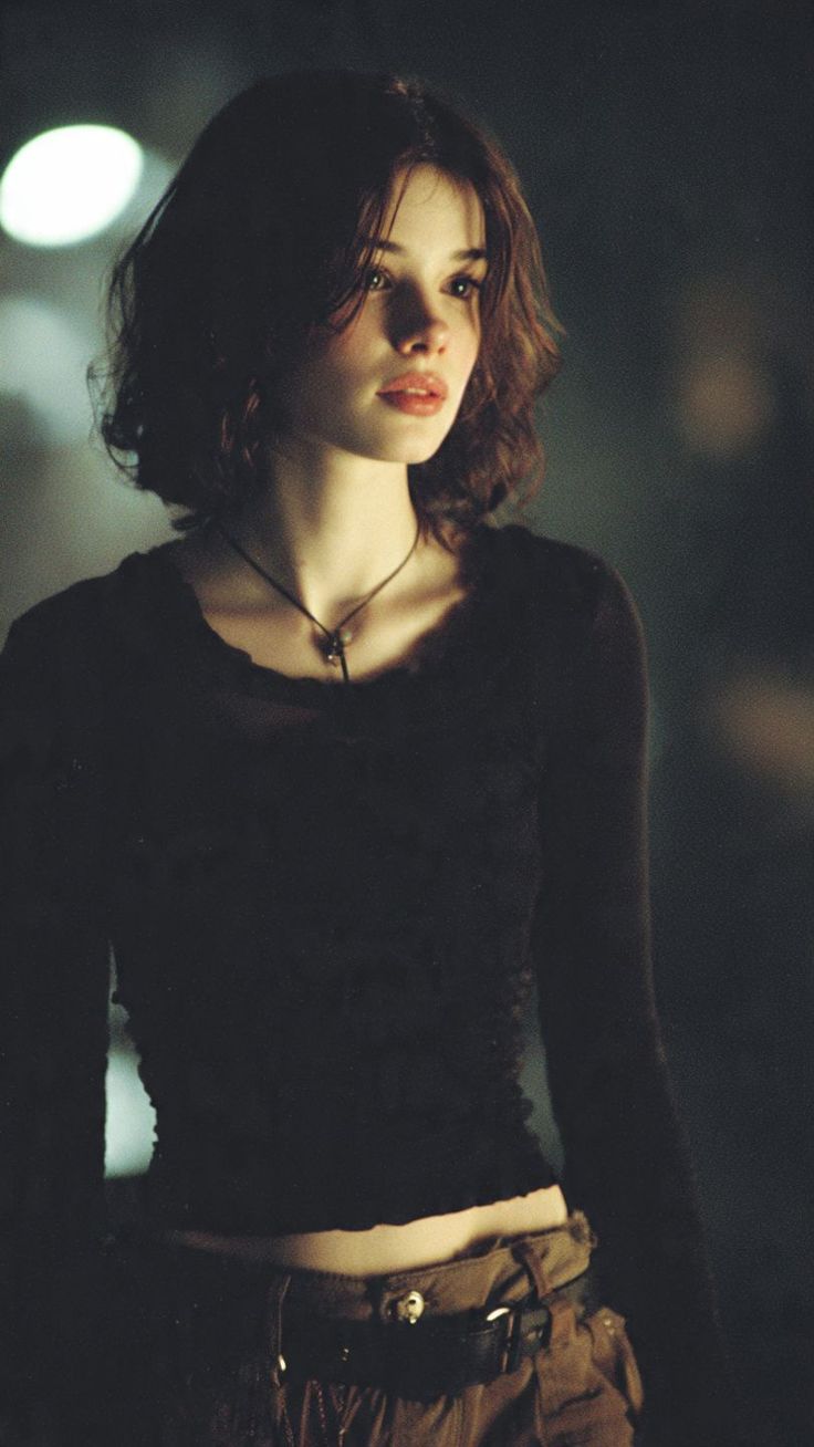 Woman with short hair and a dark top, showing exposed midriff