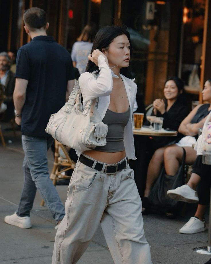Woman in a crop top and baggy jeans walking on a street