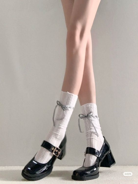 Person wearing black mary jane shoes with white socks and bows