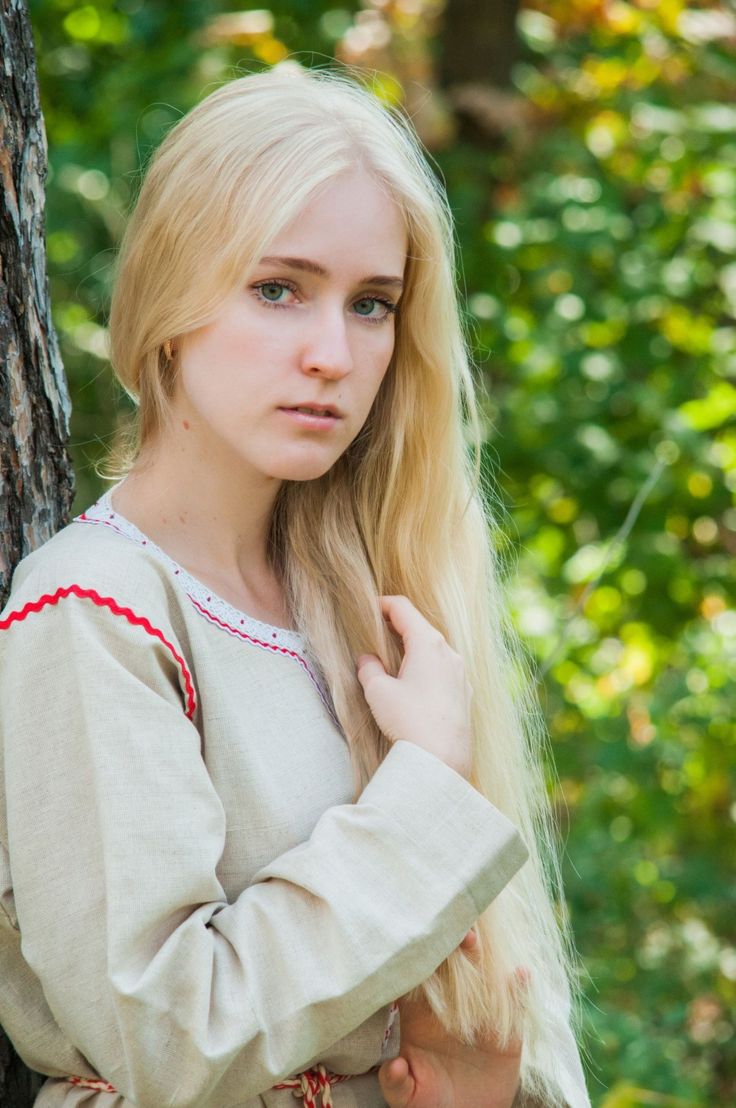 Woman with long blonde hair in an embroidered dress outdoors