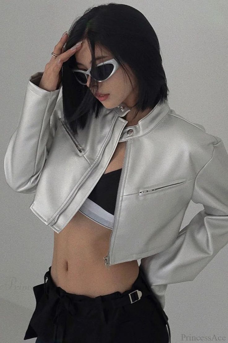 Woman in a silver jacket and sunglasses with exposed midriff