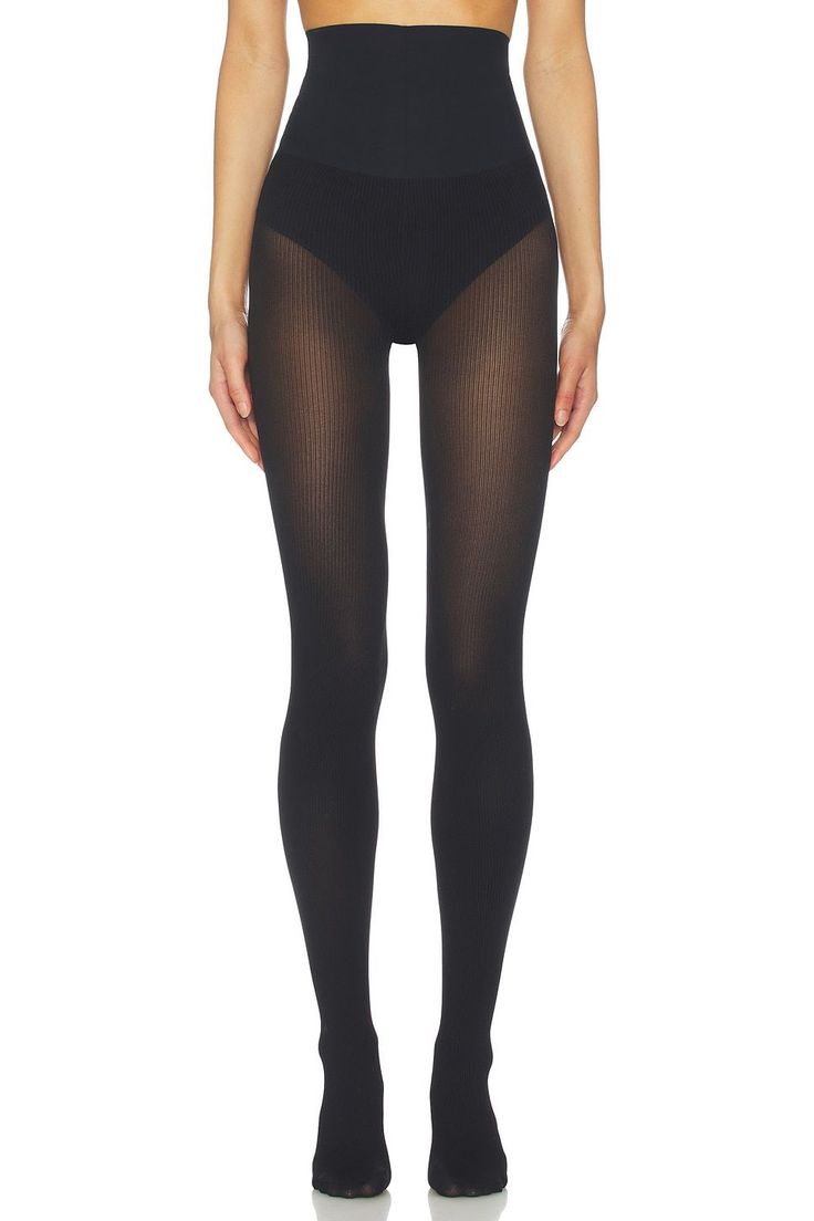 Person wearing black ribbed tights with a high waist on a white background