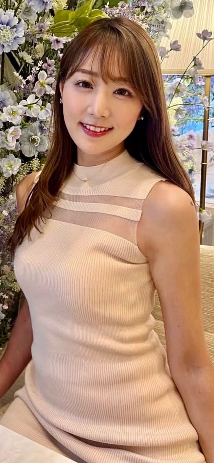 Woman with long hair wearing a sleeveless ribbed top with sheer fabric details