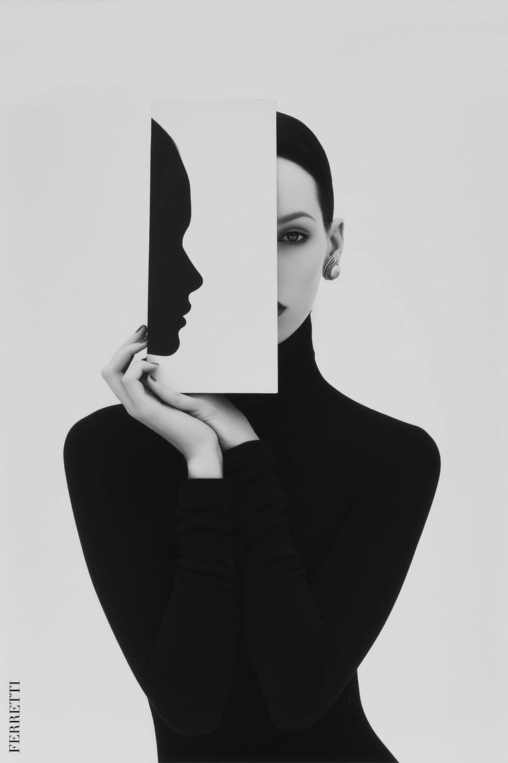 Woman in a black turtleneck holding a paper cutout of a profile silhouette