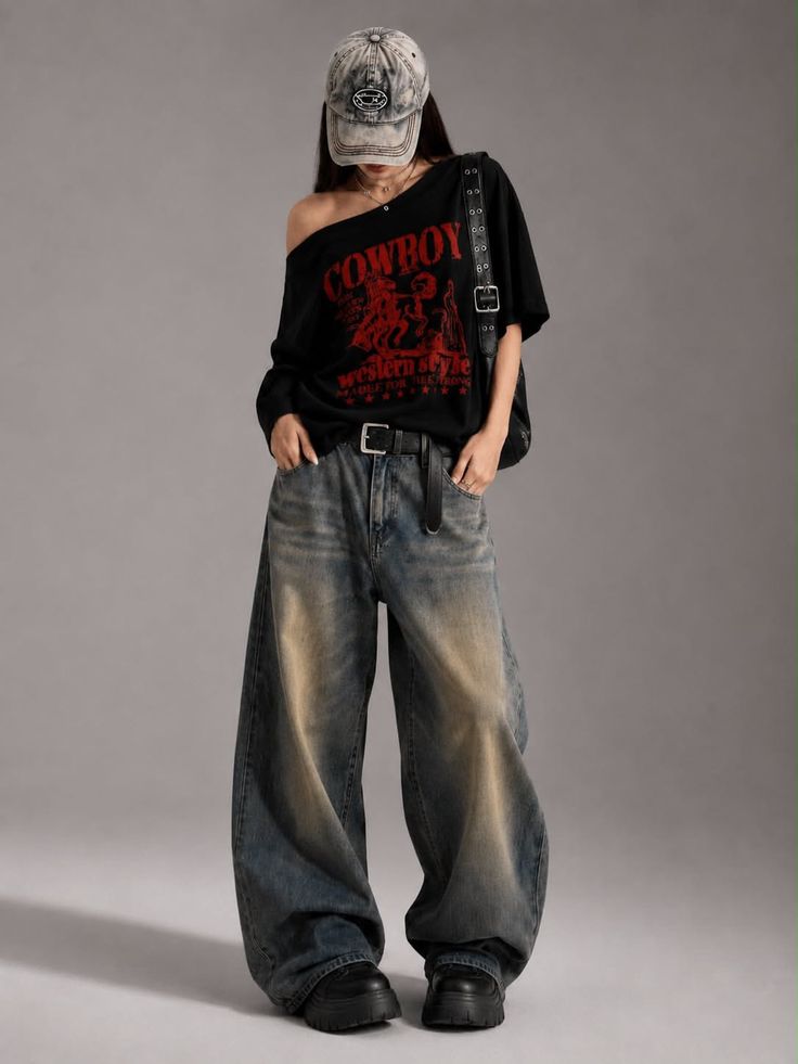 Person in an oversized t-shirt, baggy jeans, and a baseball cap in a studio